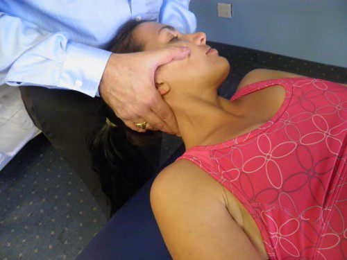 Woman receiving cervical chiropractic neck adjustment